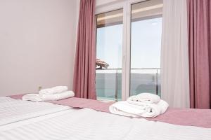 een slaapkamer met een bed met handdoeken en een raam bij Apartments Koteski in Ohrid