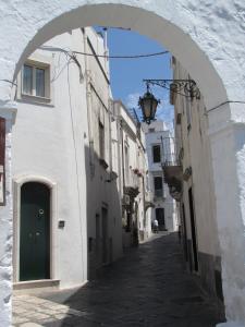 een steegje met een boog in een wit gebouw bij B&B Huit in Martina Franca