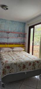 Água BoaCasa Itapema SC的卧室里有一张铺着花卉床罩的床