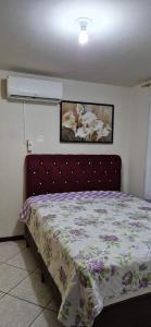 Água BoaCasa Itapema SC的卧室里有一张铺着花卉床罩的床