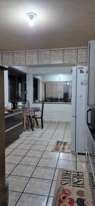 Água BoaCasa Itapema SC的厨房配有桌子和冰箱。