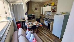 una cucina con un divano e un tavolo in una stanza di Apartamentos com 2 quartos Praia de Itapema a Itapema