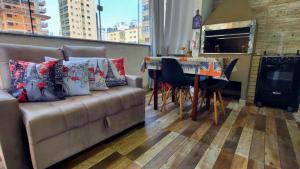 un soggiorno con un divano e un tavolo di Apartamentos com 2 quartos Praia de Itapema a Itapema