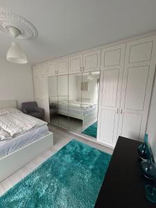een slaapkamer met witte kasten en turquoise vloerkleden bij Oberalm Apartment Gemütliche 2 Zimmer Wohnung in Oberalm +18 foto's