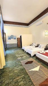 a large room with two beds and a rug at Riad Dar Mazaj Fes in Fez