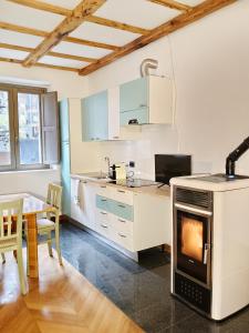 a kitchen with a stove and a table in it at Ca Poschiavini - Casa Lares in Casa Piali