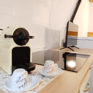 a desk with two coffee cups and a printer at Ca Poschiavini - Casa Lares in Casa Piali