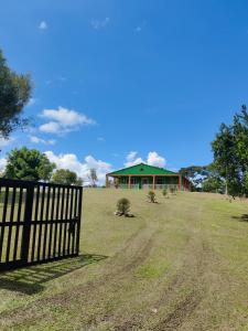a fence in front of a house in a field at Finca Turistica Rancho Grande in Santana
