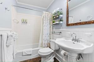 a white bathroom with a sink and a toilet at The Island Suite at KW Vacation in Key West +21 photos