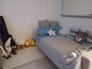 a bedroom with a bed and a couch with pillows at Ηome & Garden with parking close to Olympic Stadium in Athens