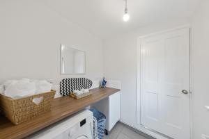 a bathroom with white walls and a counter with a mirror at 12 osbourne road in Gillingham +25 photos