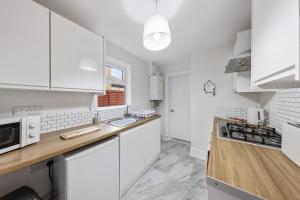 a kitchen with white cabinets and a counter top at 12 osbourne road in Gillingham