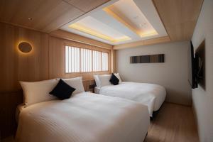 two beds in a room with a skylight at soyo-ka kyoto sanjo in Kyoto +112 photos