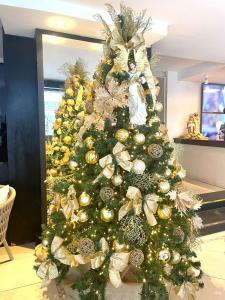 un arbre de Noël avec des ornements d'or et de blanc dans l'établissement Sandri City Hotel, à Balneário Camboriú