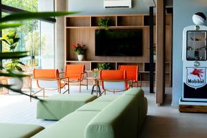 un soggiorno con divano, sedie e TV di Liwe Hotels a Penha