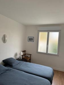 une chambre avec un lit bleu et une fenêtre dans l'établissement Ar Marc'h-Mor Glaz beach 60 meters, à Cléder