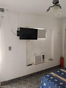 een kamer met een magnetron en een tv aan de muur bij Monoambiente de Popa in Victoria