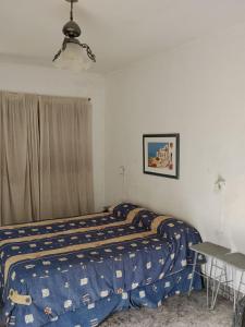 een slaapkamer met een bed, een tafel en een raam bij Monoambiente de Popa in Victoria