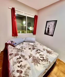 een slaapkamer met een bed met een bloemenpatroon bij Quarto Praia Economico in Matinhos