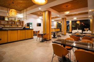 a restaurant with tables and chairs and a bar at Perast Garden Hotel in Cıralı