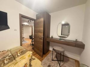 a bedroom with a bed and a mirror and a stool at Gohemi Apartments in Pirot
