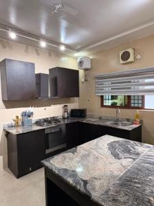 een keuken met zwarte kasten en een granieten aanrecht bij Imperial luxe homes in Araromi