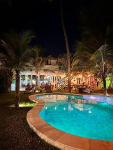 ein Schwimmbad vor einem Resort in der Nacht in der Unterkunft Pousada Bate Vento in Itarema