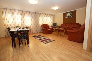 ハイドゥソボスローにあるZoli Apartmanok-Bródy 51-53のリビングルーム(テーブル、椅子、ソファ付)