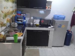 een kleine keuken met een spoelbak en een koelkast bij kire homes in Nakuru