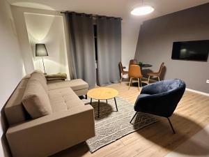 un soggiorno con un divano, un tavolo e delle sedie di Layla's Home Free Parking a Sarajevo