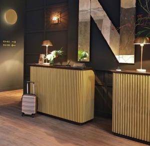 Eine Lobby mit einem Schreibtisch, auf dem ein Koffer steht, und Lampen. in der Unterkunft Residenza Toledo in Neapel