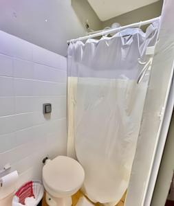 un bagno con un water e una tenda da doccia di The Red, Vem que tem Sol a Matinhos Altre 13 foto