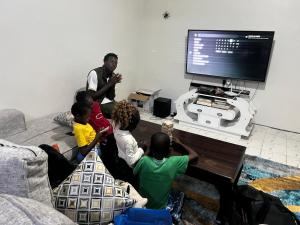 een groep kinderen die voor een tv zitten bij kire homes in Nakuru