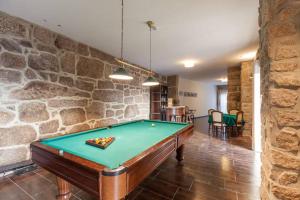 a pool table in a room with a stone wall at Casa da Ventozella in Penafiel