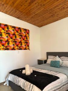 een slaapkamer met een bed en een schilderij aan de muur bij Cabañas Mountain View in Paso Ancho