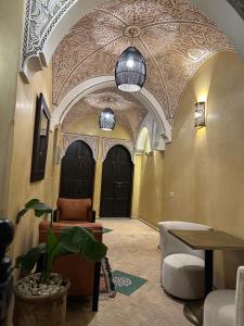 a hallway with two black doors and a potted plant at Riad Jadis in Marrakesh
