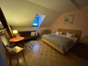 ein Schlafzimmer mit einem Bett, einer Couch und einem Tisch in der Unterkunft Burghof Ferienwohnungen Görlitz Apartmenthaus in Görlitz