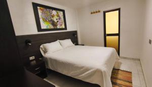 a bedroom with a bed and a painting on the wall at Departamento centro in Andahuaylas