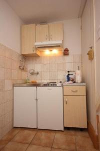a small kitchen with white cabinets and a stove at Apartments Mat in Vis