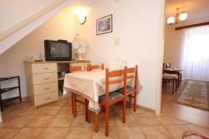 a dining room with a table and a tv at Apartments Mat in Vis