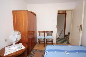 a room with a bed and two chairs in it at Apartments Mat in Vis