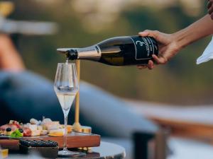eine Person, die eine Flasche Wein in ein Glas gießt in der Unterkunft V Villas Phuket - MGallery Collection in Panwa Beach