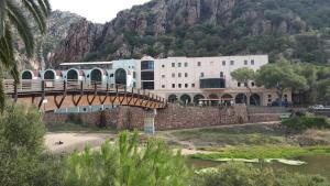 a bridge over a river in front of a building at Casa Vacanze residence Cavour Attico in Valledoria