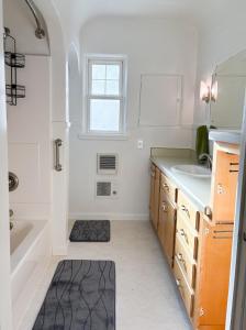 a white bathroom with a tub and a sink at 1 Min to Hospitals Spacious 4 Bed Stay in Billings