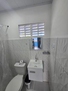 a white bathroom with a toilet and a sink at Pousada Hostel Beach Pajuçara in Maceió