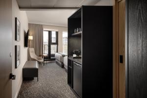 een hotelkamer met een deur naar een slaapkamer bij Peaks Hotel and Suites in Banff