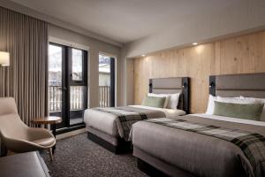 een hotelkamer met twee bedden en een raam bij Peaks Hotel and Suites in Banff +53 foto's