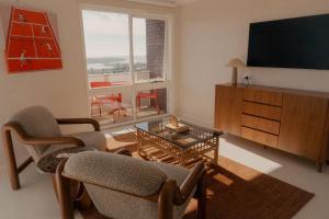 een woonkamer met twee stoelen en een televisie bij Hillcrest Merimbula in Merimbula