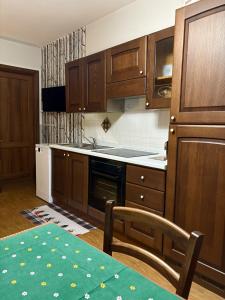 a kitchen with wooden cabinets and a stove top oven at Rifugio delle Emozioni in Grange Sises