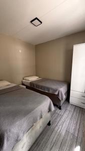 een kamer met 2 bedden en een tv. bij Ali Baba Butik Otel in Gündoğdu